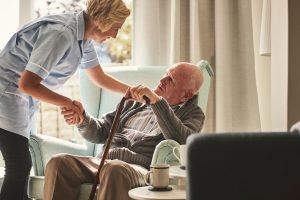caregiver helping elderly man with mesothelioma